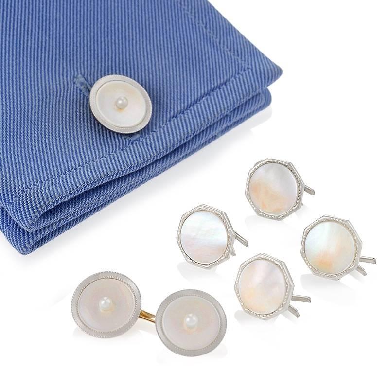 An American Art Deco 14 karat gold and platinum pair of cuff links with mother of pearl and pearl by Carrington & Company. The pair of cuff links are made of mother of pearl disks  with a 2 mm cultured pearl set in the center framed in engine turned