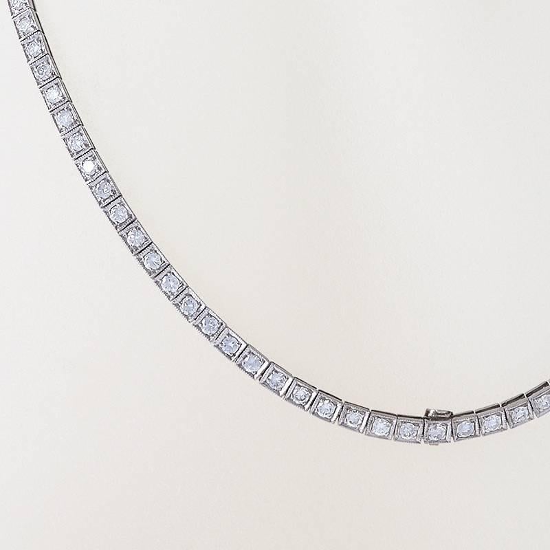 A Mid-Century diamond and platinum necklace containing 110 round-cut diamonds with an approximate total weight of 5.90 carats, H/I color, VS clarity. Each diamond is prong set in a box link. The center of the necklace has a flip down bale.  Circa