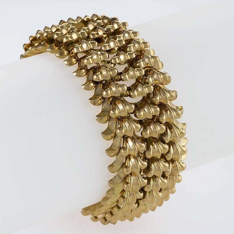 A Retro 18 karat gold bracelet. The flexible bracelet is composed of 3 rows of Retro-styled elevated floret links.  Circa 1950's.

(MG #18107)