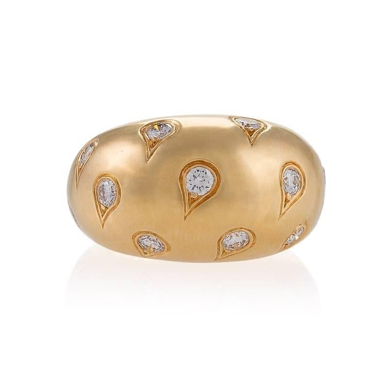 A French Late-20th Century 18 karat gold ring with diamonds by Cartier. The bombé ring has 11 brilliant-cut diamonds with an approximate total weight of 0.80 carat, F/G color, VS clarity. The diamonds are set in rain-drop engraved prong settings.