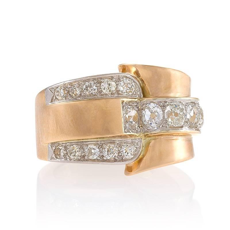 This splashy European Retro gold ring with diamonds re-imagines the buckle ring as a chic abstraction. The polished scrolling shank centers on a stylized depiction of a buckle strap and hardware, creating fascinating design tension. Set into white