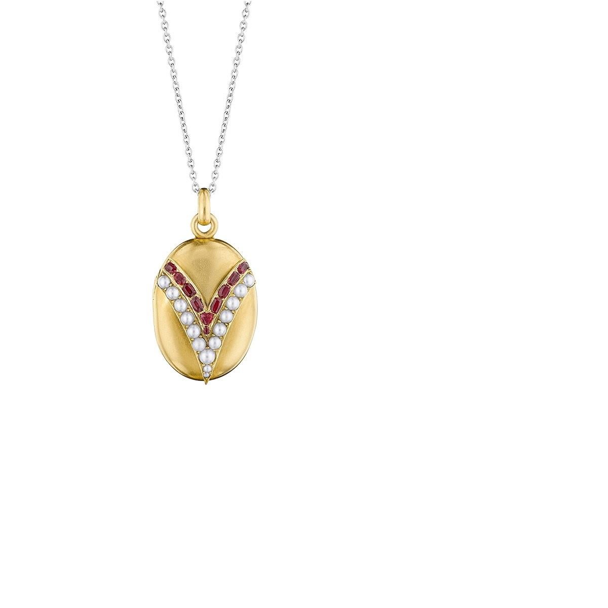 An English Victorian 18 karat gold locket with seed pearls and rubies. The locket has 5 seed pearls and 10 mixed rubies with an approximate total weight of 1.00 carats.  Circa 1870's.
