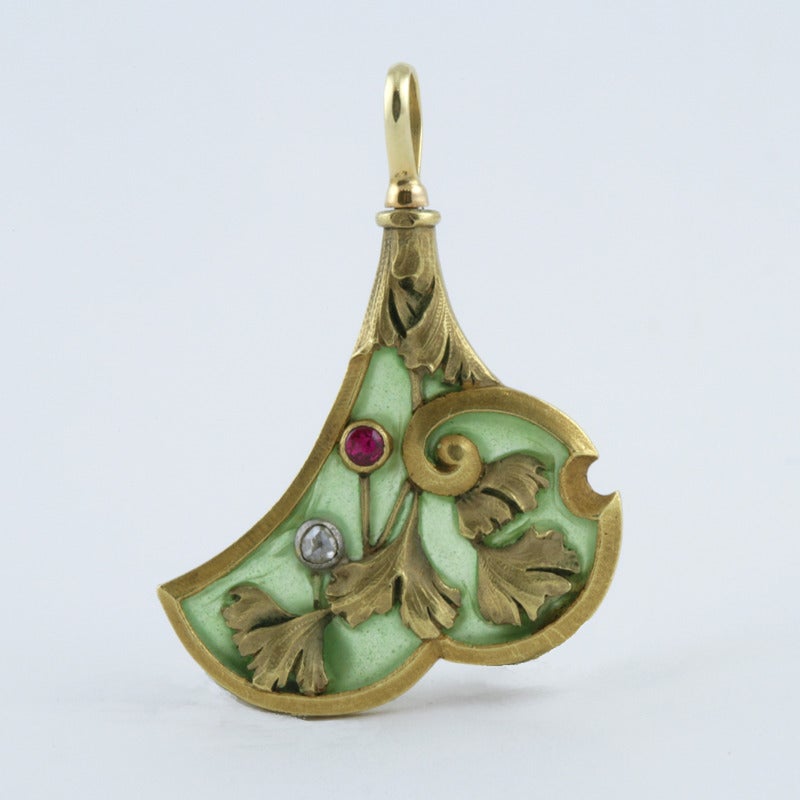 A French Art Nouveau 18 karat gold and plique-a-jour pendant with diamonds and rubies. The pendant has 2 rose-cut diamonds  with an approximate total weight of .05 carats, and 2 rubies with an approximate total weight of .05 carats. In a floral