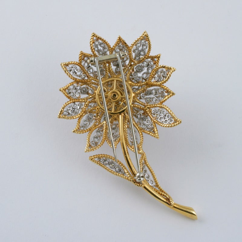 An American Mid-20th Century 18 karat gold and platinum brooch with diamonds. The brooch has 138 round-cut diamonds with an approximate total weight of 6.90 carats. The brooch is made in a chrysanthemum motif. Circa 1960s. 

(MG #16218)