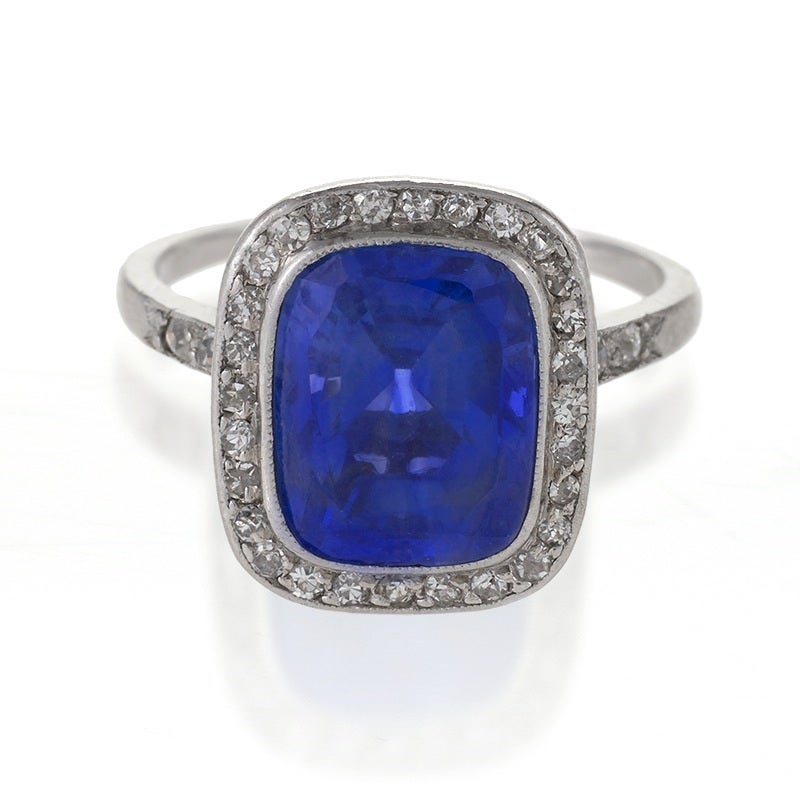 A French Art Deco platinum ring with blue sapphire and diamonds. The ring has a rectangular cushion-cut blue sapphire with an approximate total weight of 4.85 carats, and 34 old European-cut diamonds with an approximate total weight of .34 carats.