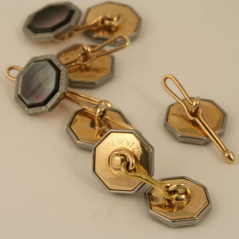 An American Art Deco 14 karat gold and white metal dress set with abalone shell by Krementz & Co. The dress set has octagonal cut abalone shell, gold mounted, with diamond cut platinum frames.  The cufflinks are double sided with 4 buttons for