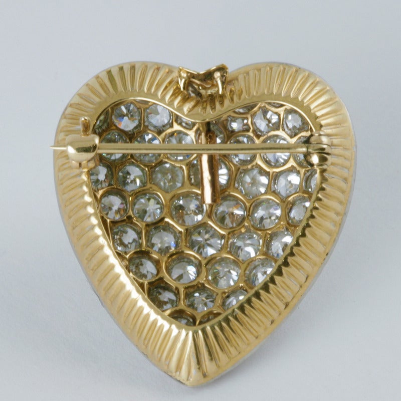 A Mid-20th Century 14 karat gold and platinum brooch with diamonds. The brooch has 68 old European-cut diamonds with an approximate total weight of 5.10 carats. The heart-shaped brooch has a convertible pendant bale and deeply ribbed gallery.  Circa