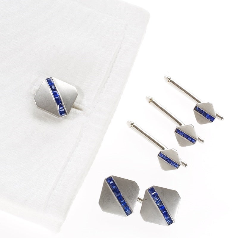 A Tiffany & Co. platinum Art Deco 5-piece cuff link set with sapphires weighing approximately 2.05 carats.  The dress set is designed with diagonal stripes of square-cut sapphires bisecting the square cuff link tops.  The cuff links are double