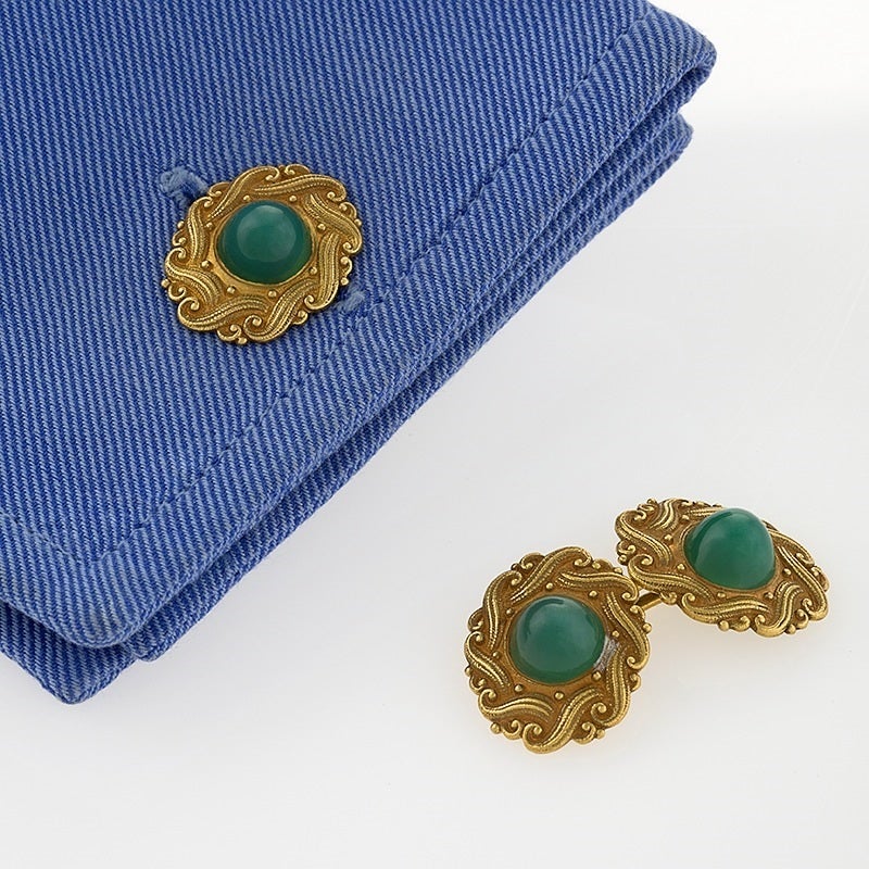 A pair of European Art Nouveau 18 karat gold cuff links with green chrysophrase. The oval shaped cuff links have 4 cabochon green chrysophrase stones surrounded by high relief engraved scroll work. Double sided.  Circa 1900. 

European Control marks