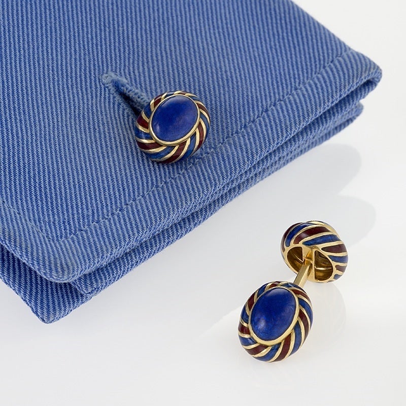 A pair of American Mid-20th Century 18 karat gold and enamel cuff links by David Webb. The cufflinks are double sided ovals with spiraling red and blue enamel in a turban motif.     Circa 1960-70. 

Signed, Webb 18k. (partial)

(MG #16713)