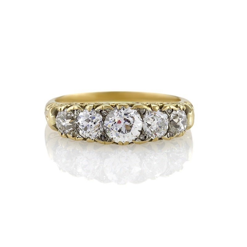 An English Antique 18 karat gold ring with diamonds. The ring has five old European-cut diamonds with an approximate total weight of 1.30 carats, accented with 8 rose cut diamonds. In a classic five stone design. Circa 1900. 

Size:  6-1/4; this