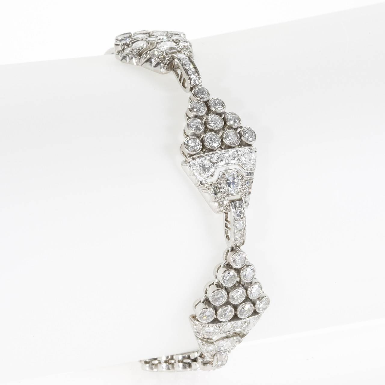 An Art Deco platinum and diamond bracelet.  The bracelet is set with old European-cut diamonds with an approximate total weight of 9.35 carats. The bracelet is composed of 6 diamond-set plaques separated by diamond-set links. Circa 1920's. 


(MG
