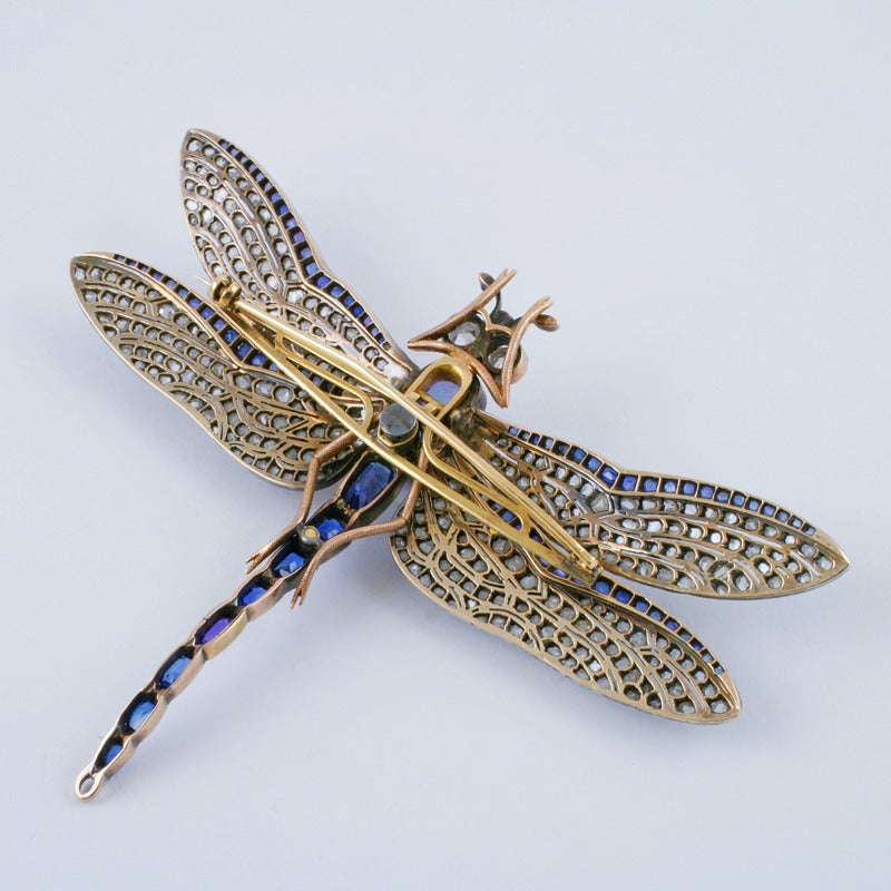A European Antique 18 kt gold and oxidized silver dragonfly brooch with diamonds and sapphires. The brooch has 352  rose-cut diamonds with an approximate total weight of 5.60 carats, 9 rectangular-cut sapphires with an approximate total weight of