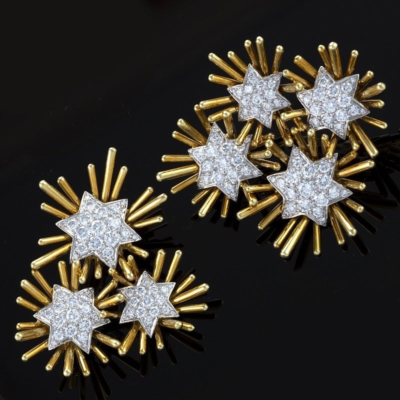 A pair of American Mid-20th Century 18 karat gold and platinum brooch with diamonds by Verdura. The pair of  brooches have 7 diamond set platinum stars with an approximate total weight of 6.50  carats, F/G color, VS clarity. One of the pair have 4