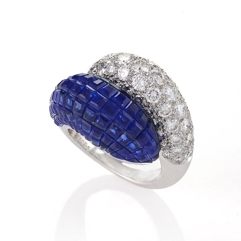 A French Late-20th Century platinum and 18 karat gold ring with diamonds and sapphires by Van Cleef & Arpels. The ring has 60 round-cut diamonds with an approximate total weight of 8.85 carats, F/G color and VVS clarity grade. The opposite side has