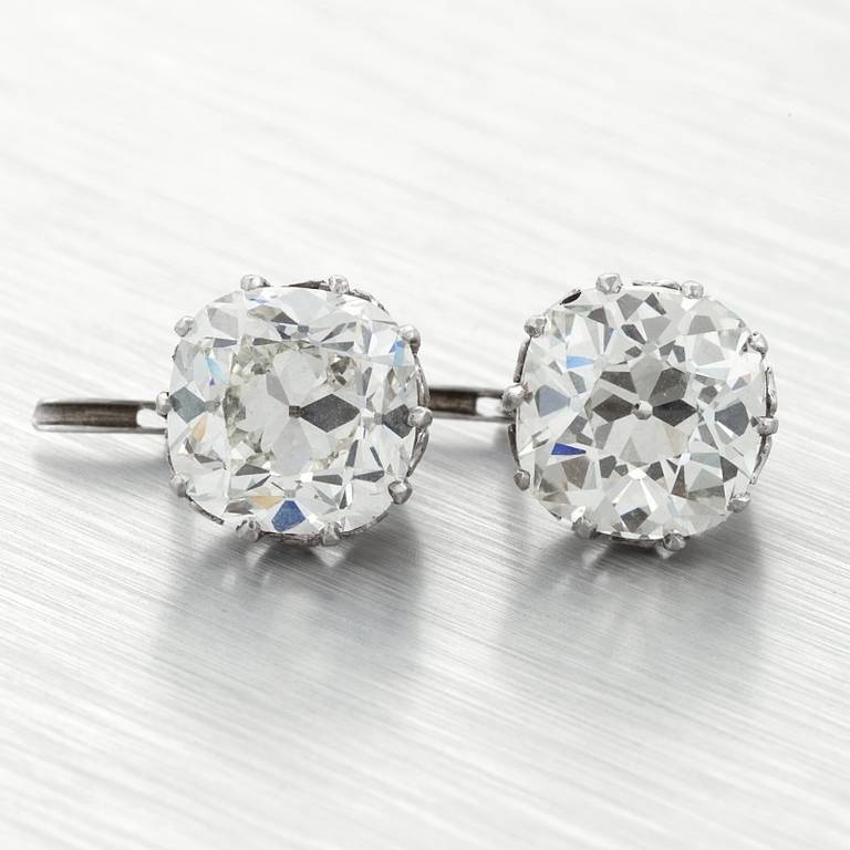 A pair of French Antique platinum earrings with diamond. The earrings have an old mine-cut diamond with an approximate total weight of 5.75 carats, and a matching old mine-cut diamond with an approximate total weight of 6.00 carats that have a K/L