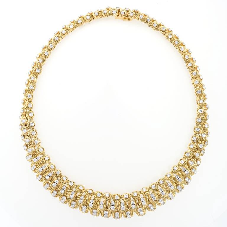 A Mid-20th century 18 karat gold necklace with diamonds. The necklace has 184 round-cut diamonds with an approximate total weight of 14.70 carats, G/H color,VS clarity. The necklace is designed in a diamond set layered rope motif. Circa