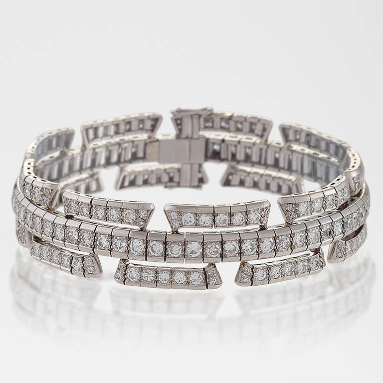 An Art Deco platinum and diamond bracelet, featuring 230 Old European-cut diamonds with an approximate total weight of 9.40 carats, VS clarity and H-I color grade. In a modified brick motif. Circa 1930. 

(MG #10896)