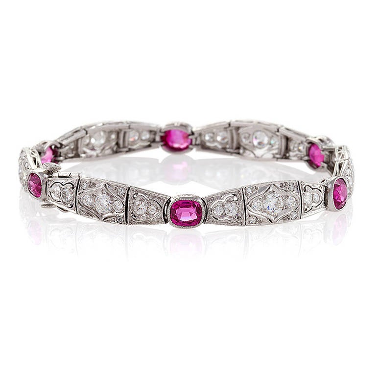 An Art Deco platinum, diamond and ruby bracelet. The bracelet is comprised of 66 Old European cut diamonds with an approximate total weight of 2.70 carats, H/I color, VS clarity. The diamond plaques are separated by 6 cushion-cut  milligrain set