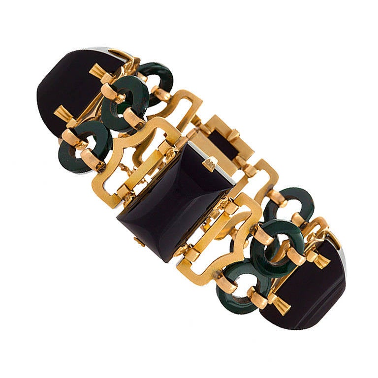 A Mid 20th Century 18 karat gold bracelet with onyx and bloodstone.  The gold links are connected by double 'O' bloodstones and cabochon carved onyx links. 

(MG Inventory # BA13809)