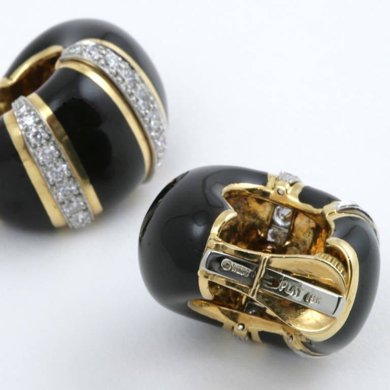 A pair of American Mid-Century  platinum, 18 karat gold, enamel and diamond earrings by David Webb. The earrings feature polished gold strips and black enamel alternating with inset rows of 40 round-cut diamonds with an approximate total weight of