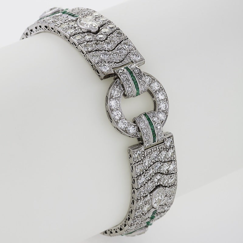 An Art Deco platinum bracelet with diamonds and emeralds. The bracelet has marquise and round-cut diamonds with an approximate total weight of 12.90 carats including 2 larger marquise diamonds that are approximately .80 ct. each. The bracelet is