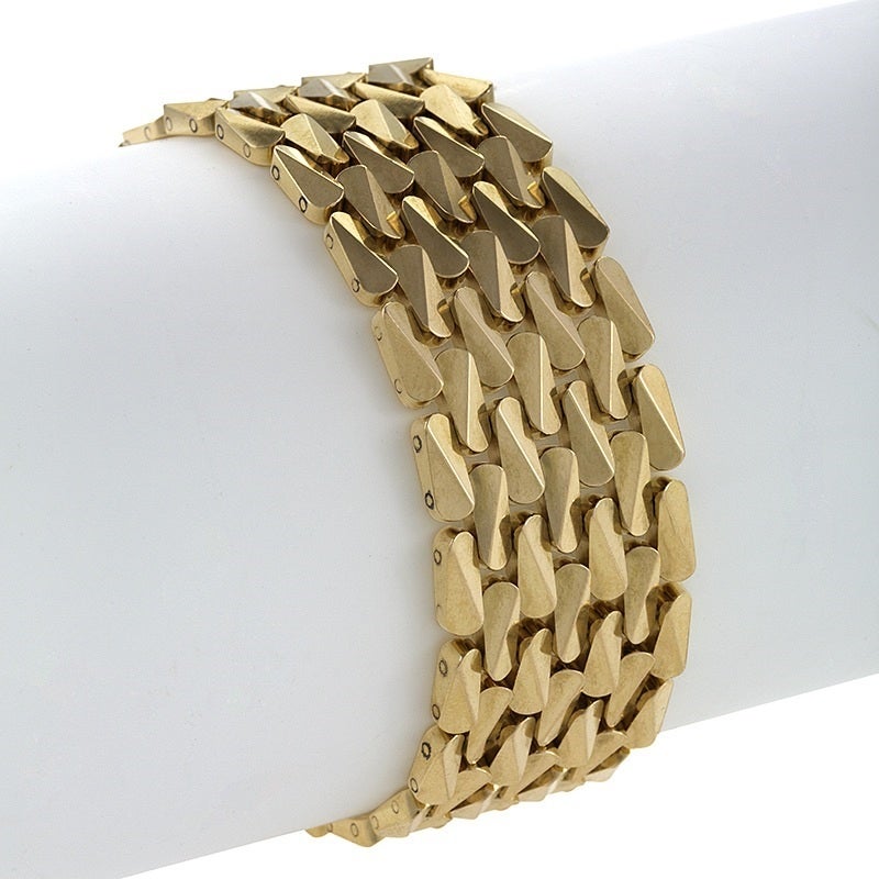 A French mid-20th century 18 karat gold and platinum bracelet with diamonds. The bracelet has 7 graduated round-cut diamonds with an approximate total weight of .85 carats. The bracelet is composed of 3-dimensional oval shaped elements in an