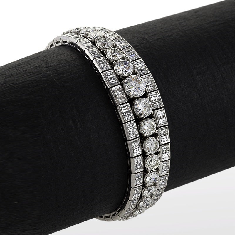 Elegance is distilled to its purest form in this flexible, triple line platinum bracelet with diamonds from the mid-20th century. The central diamond line, composed of graduated round-cut diamonds, is flanked by double lines of baguette-cut