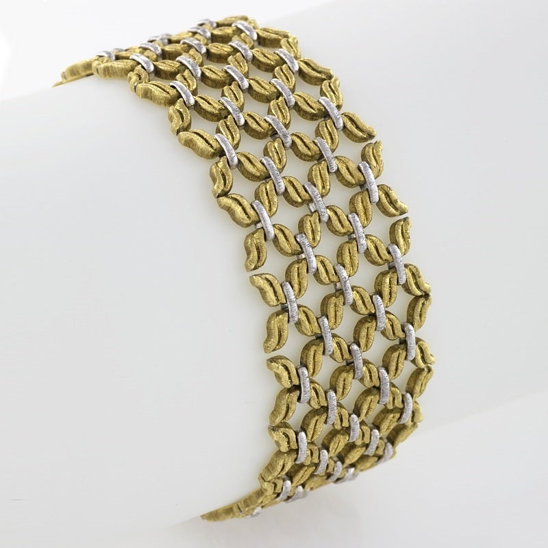 An Italian 18 karat gold bracelet by Buccellati. The highly flexible woven link bracelet is composed of textured fancy-shaped yellow links joined by textured white gold bar links, reminiscent of a Renaissance ruff collar motif.  The bracelet can