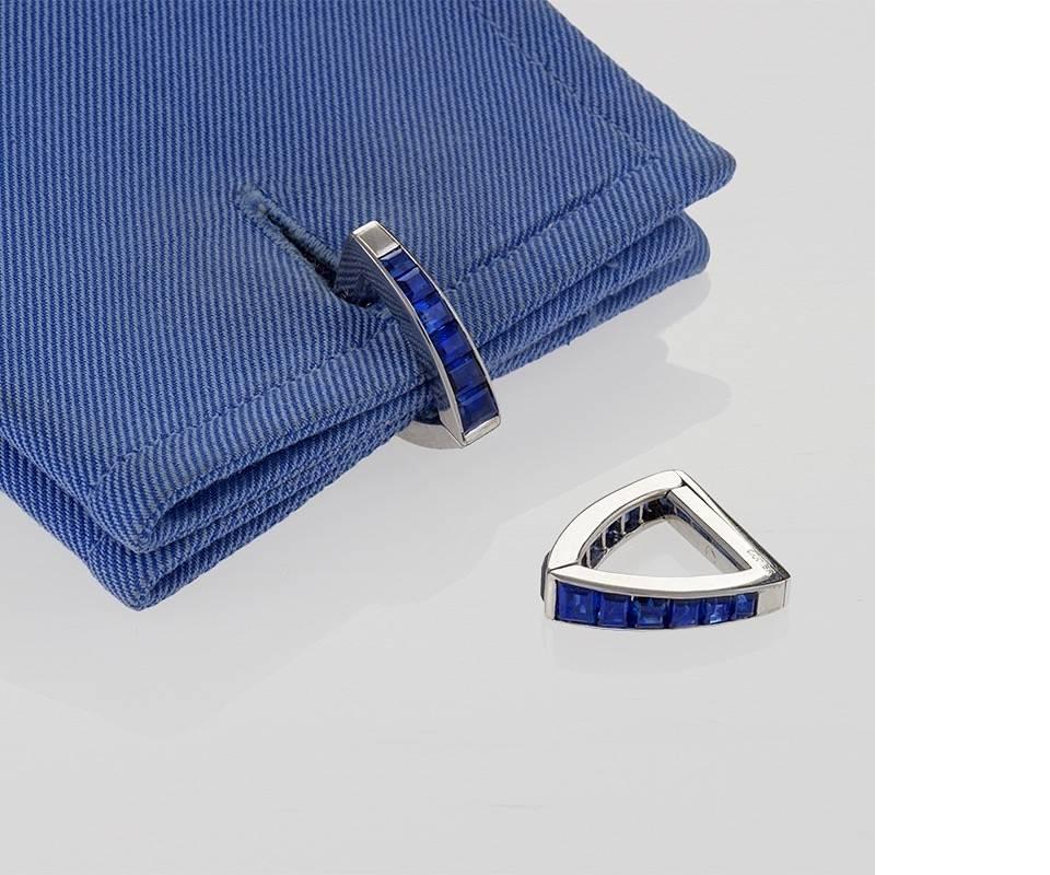 A pair of Mid-20th Century 18 karat gold cuff links with sapphires by Cartier. The cuff links have 24 calibre-cut sapphires with an approximate total weight of 2.90 carats. In signed Cartier box. Circa 1950’s. 

Pictured in Cuff Links, by Susan