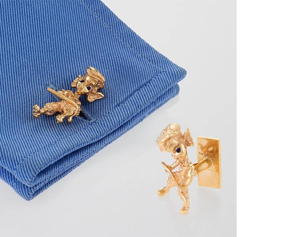 A pair of American Mid-20th Century 14 karat gold cuff links with sapphires by William Ruser. The cuff links have 4 round sapphires with an approximate total weight of .04 carats. The cuff links are designed in Ruser's famous cherub motif with
