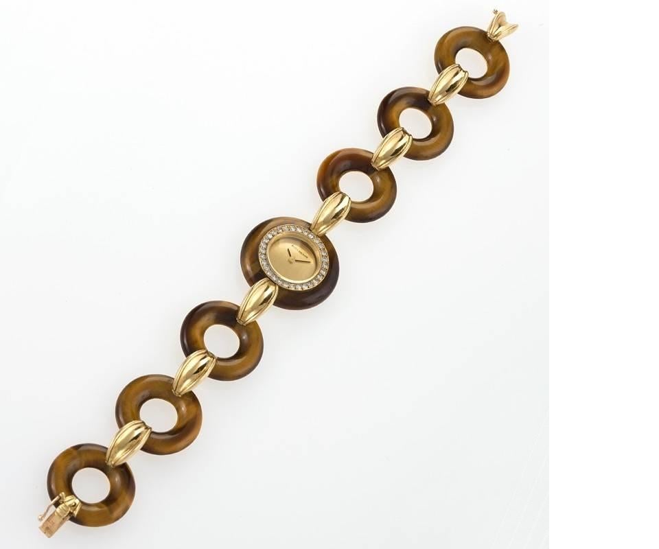 A French Mid-20th Century 18 karat gold watch with tiger's eye and diamonds by Boucheron. The watch has 6 tiger's eye and gold alternating links and 30 round diamonds surrounding the dial, with an approximate total weight of .45 carat.  Circa