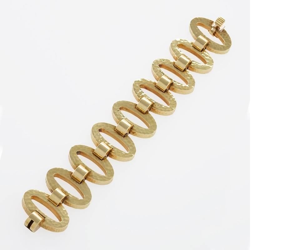 An Estate 18 karat gold bracelet. The flexible bracelet is composed of 9 hammered oval links which alternate with 9 polished links.  Retailed by Neiman Marcus. Circa Estate. 

Signed, “707011NM” ( for Neiman Marcus) “18kt”. 
(MG #17255)