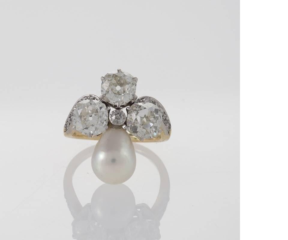 An American Early 20th Century platinum and 18 karat gold ring with diamonds and natural pearl by Marcus & Co. The ring has 3 old mine-cut diamonds with an approximate weight of 1.25, 1.35 and 1.05 carats, L/M color, SI clarity respectively, and 10