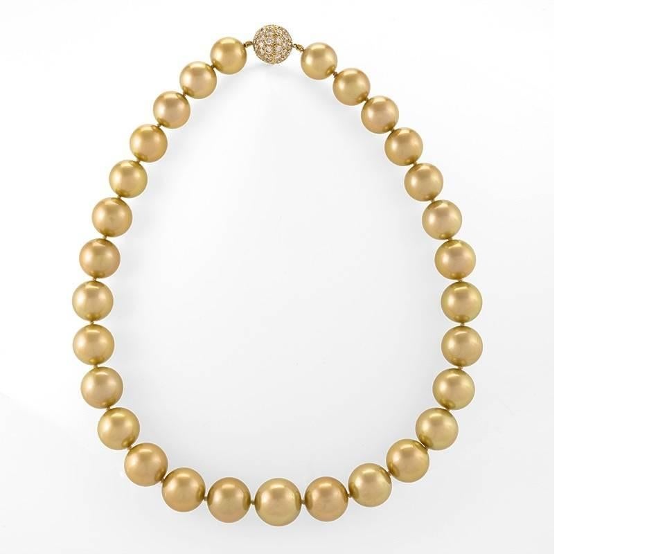 A cultured golden South Sea pearl necklace that features 29 round pearls that measure 15.7mm in the center of the necklace and graduate in size to 13.1mm in the back of the necklace. The pearls are strung and knotted on silk and are finished with an