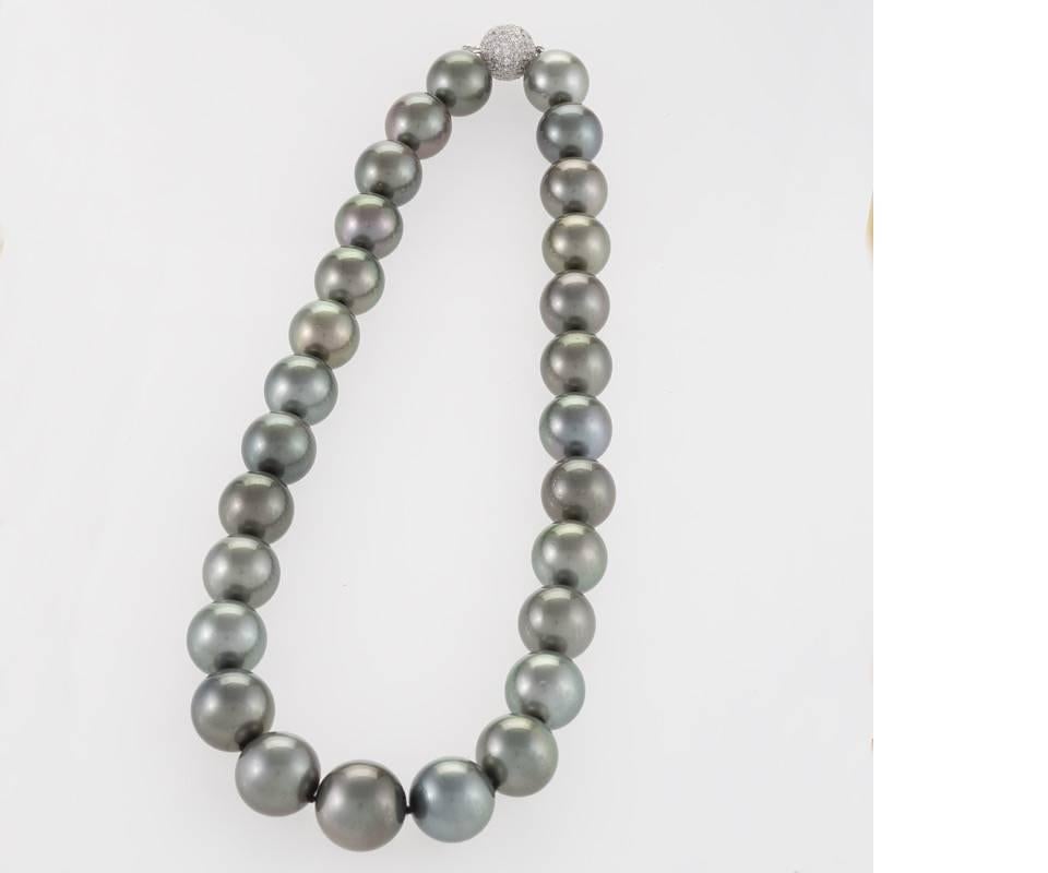 A cultured dark silver Tahitian pearl necklace that features 27 round pearls that measure 17.7mm in the center of the necklace and graduate in size to 13mm in the back of the necklace. The pearls are strung and knotted on silk and are finished with