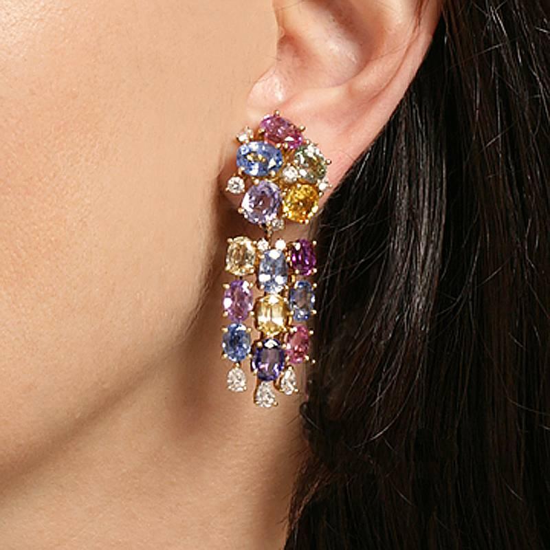 A pair of Swiss Mid-20th Century 18 karat gold earrings with sapphires and diamonds by Meister. The earrings have 28 multi colored sapphires with an approximate total weight of 17.40 carats, and 22 diamonds with an approximate total weight of 1.70