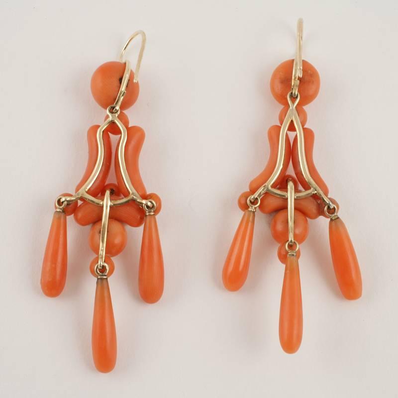 A pair of English Victorian 15 karat gold earrings with corals. The articulated earrings are composed of coral beads, half moon and teardrop forms in the 19th Century revival style of the classic girandole earrings of the 18th Century. Circa 1870.
