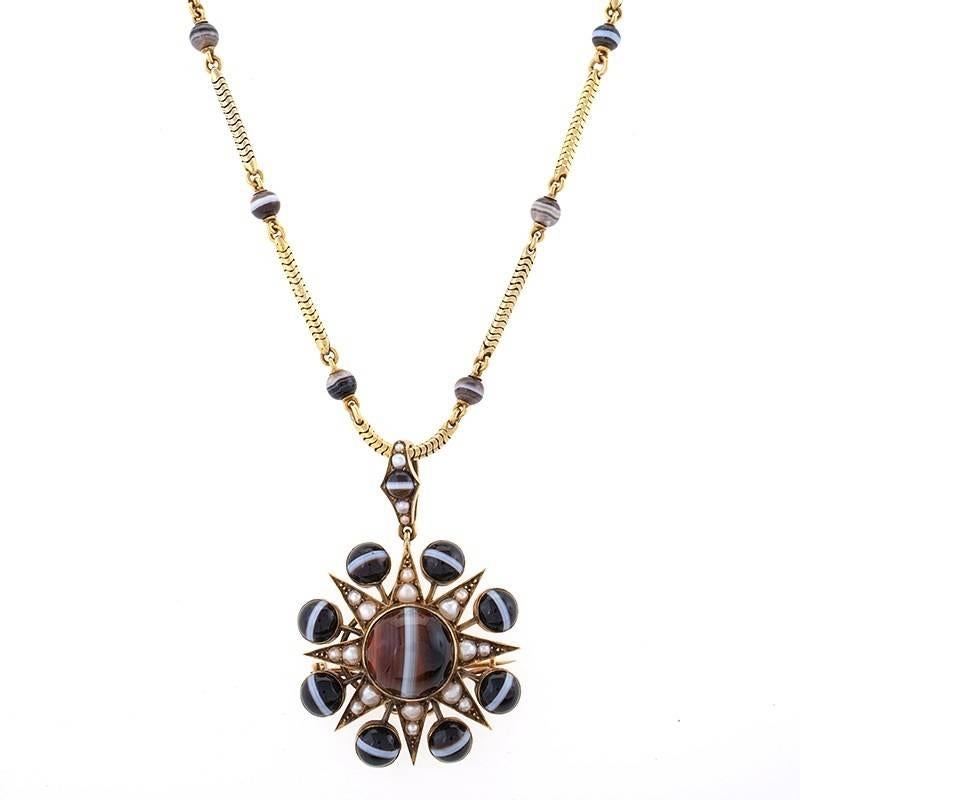 An English Victorian 15 karat gold demi-parure with banded agate and half pearl. The demi-parure has a star motif banded agate and pearl detachable pendant/brooch hanging from a woven gold necklet chain.  The suite has matching star banded agate and