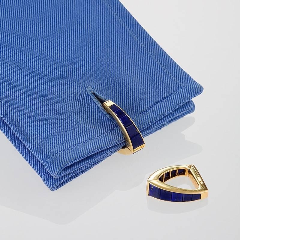 A pair of French Mid-20th Century 18 karat gold cuff links with lapiz lazuli by Jean Ferrière. The cuff links have 20 channel set lapiz lazuli stones.  The stirrup cuff links are composed in a hinged triangular form. Circa 1960's. 

Signed,