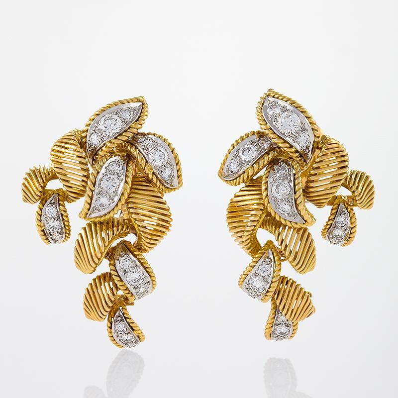 A pair of French Mid-20th Century 18 karat gold and platinum earrings with diamonds by Van Cleef & Arpels. The earrings have 36 round diamonds with an approximate total weight of 1.70 carats.  The earrings are composed in a stylized cluster