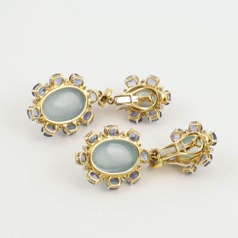 A pair of American Estate 18 karat yellow and white gold earrings with aquamarines, sapphires and diamonds by Zwikker & Zacher. These earrings have 4 oval aquamarines with an approximate total weight of 34.00 carats, 28 oval sapphires with an