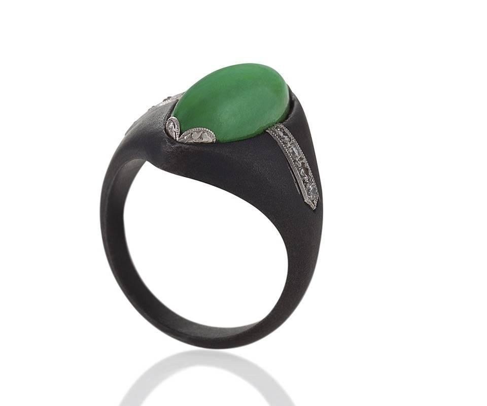 An American Mid-20th Century oxidized steel and platinum ring with jadeite jade and diamonds by Marsh & Co.. The ring has a marquise shape jadeite cabochon, and 8 round diamonds with an approximate total weight of .16 carats. 

Circa 1950’s.