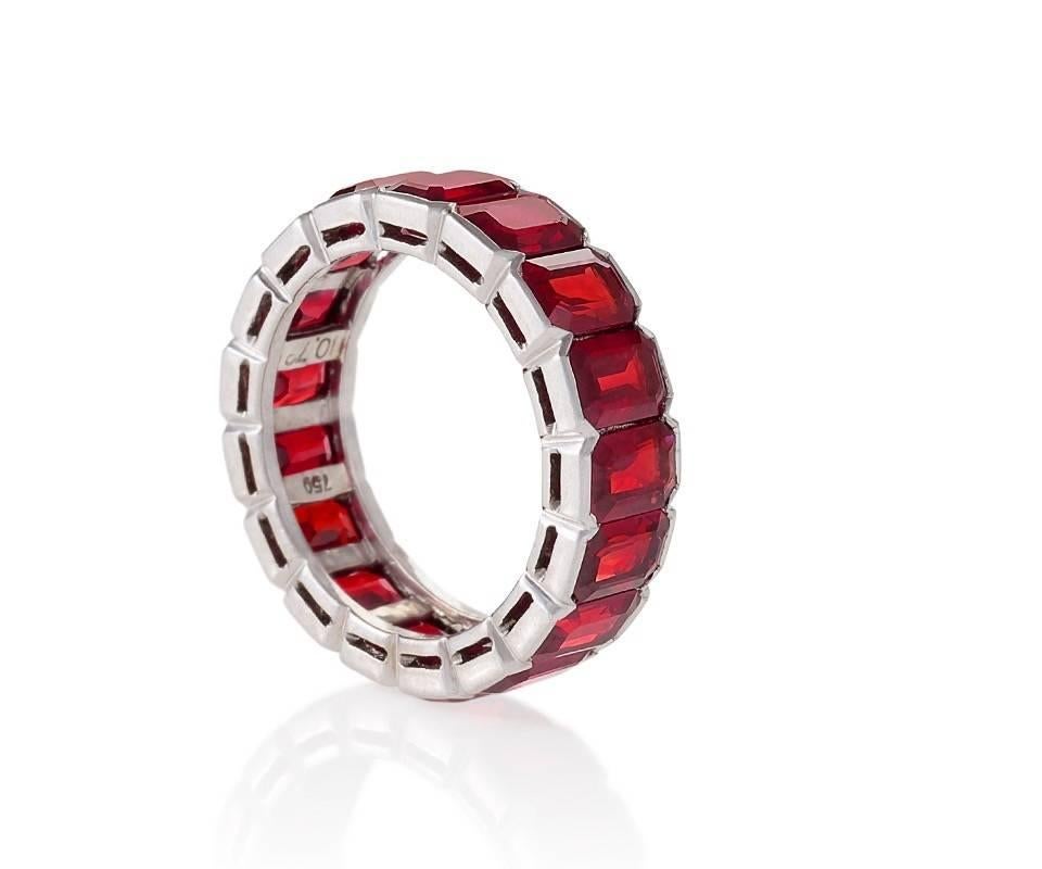 A Late-20th Century 18 karat white gold ring with rubies. The full eternity ring has 17 square cut rubies with an approximate total weight of 10.73 carats. American Gemological Laboratories Certificate #CS 1072648 stating origin as Burma, heat