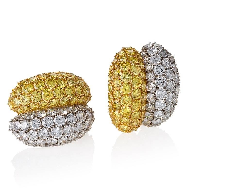 These opulent earrings by Van Cleef & Arpels are designed as segmented half hoops with over twenty carats of natural fancy vivid yellow and colorless diamonds. Side by side, the impeccable pavé-set fields of beautifully-cut stones combine the little