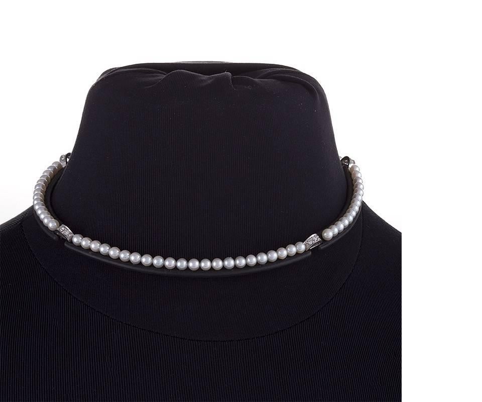 An American Mid-20th Century patinated steel and platinum necklace with cultured pearls and diamonds. The necklace has 76 cultured pearls measuring approximately 4.5 mm, and 16 round diamonds with an approximate total weight of .32 carats. Circa: 