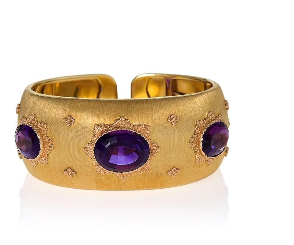 An Italian gold bracelet with amethysts by Buccellati. The bracelet has 3 bezel set amethysts with an approximate total weight of 22.10 carats  (5.50, 5.60, 11.00 carats). The cuff bracelet has a hinged clasp and is open backed. 
The bracelet