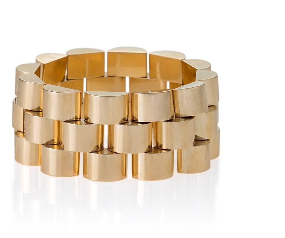 A French Retro 18 karat gold bracelet. The flexible link bracelet is composed in a dimensional curved three row brick link motif.

Following World War II, jewelry makers made heavy geometric link bracelets popular. Their inspiration for these