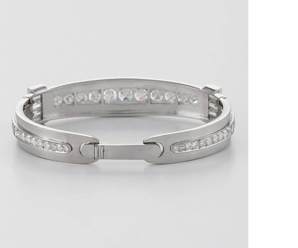 An Art Deco platinum hinged bangle bracelet with diamonds.  The bangle has 43 round cut diamonds and 8 baguette cut diamonds with an approximate total weight of 5.20 carats, H/I color, VS clarity.  The hinged bangle is made of polished platinum with