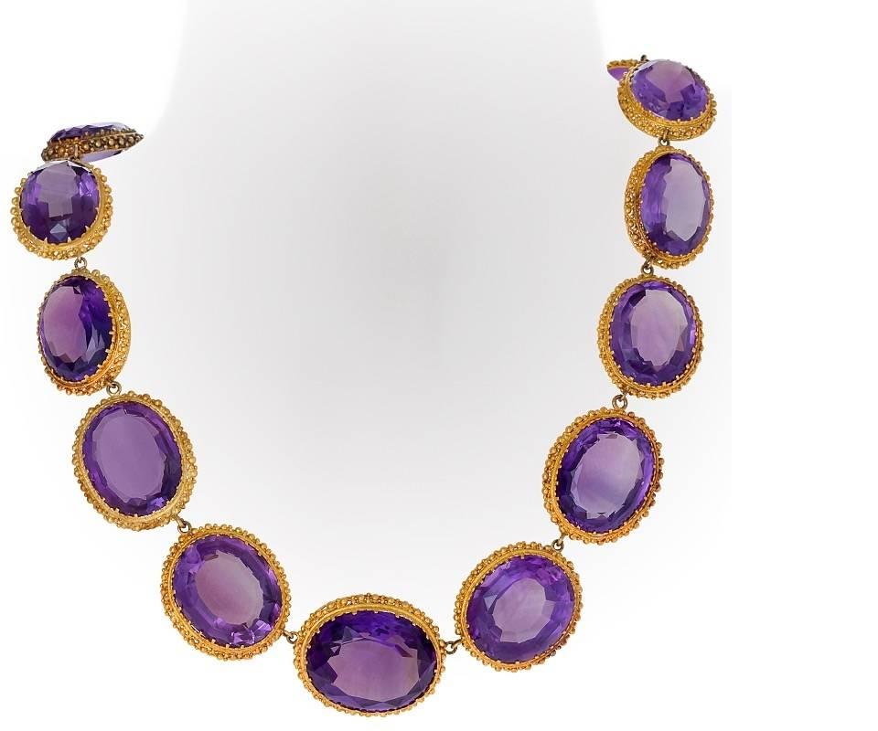 An Antique English 18 karat gold necklace with amethysts. The Rivière necklace has 16 faceted oval cut amethyst stones with a slight graduation in size, prong set in granulated gold collets, with an approximate total weight of 350 carats. Circa